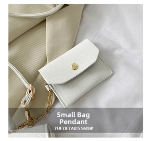 Close-up of white lychee leather mini pouch with gold metal snap and chain hook detail