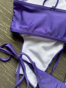 Detailed shot of purple bikini featuring stretch fabric texture and white mesh lining