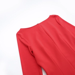 Dettaglio ravvicinato dello scollo dell'abito in maglia rossa con fiocco elegante
