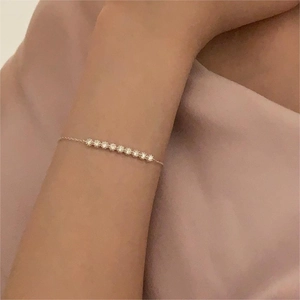 Macro shot of minimalist S925 silver bracelet with sparkling zircon stones on model wrist