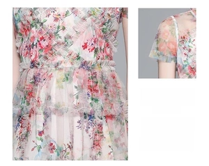 Détail d'une robe en résille à fleurs avec volants multicouches et taille cintrée