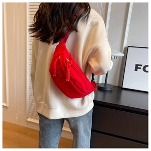 Modern red nylon crossbody chest bag with embroidery shown on a model in a bright room