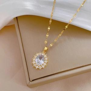 Detail of luxury gold necklace with oval crystal pendant and shimmering zircon setting