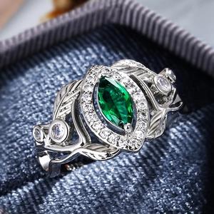 Macro shot of marquise-cut green zircon ring with vintage vine-style hollow silver band