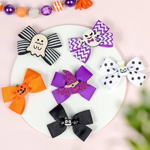 Close-up of Halloween hair bows featuring pumpkin, ghost, and bat embellishments