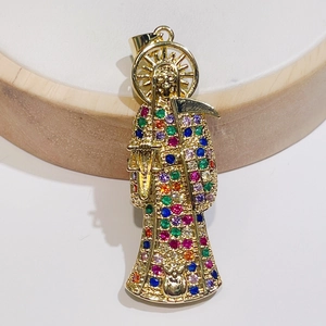 Macro shot of gold Santa Muerte pendant with colorful cubic zirconia and sickle detail