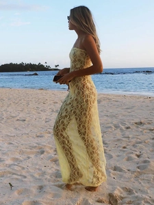 Gros plan détaillé de la dentelle jaune d'une robe bustier sur une plage au coucher
