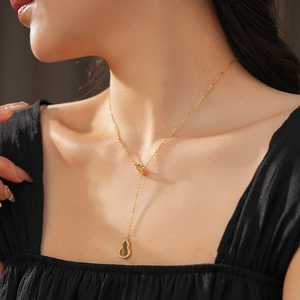 Close-up of gold gourd pendant with tiger eye stone and CZ diamonds on an O-chain