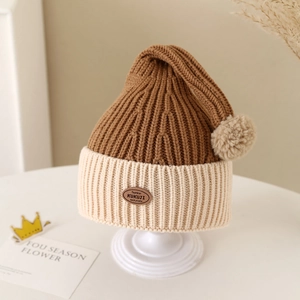 Detailed close-up of winter baby knit hat featuring warm pom-pom and leather patch label
