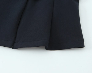 Close-up of double-needle stitching and hem detail on navy flare pants suit
