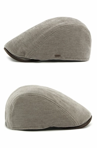 Detail view of the vintage grey corduroy fabric and metal side emblem on the flat cap