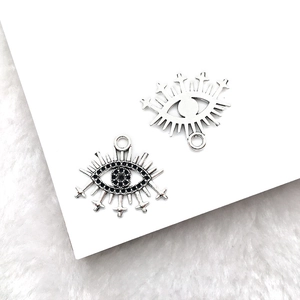 Macro shot of silver Eye of Horus pendants with black gemstone and cross details