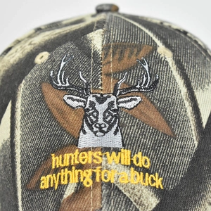Détail de la broderie tête de cerf 3D sur casquette camouflage avec texte jaune