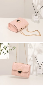 Detailed view of pink quilted crossbody bag with gold chain and circular lock