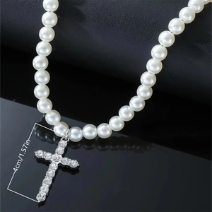 Detailed view of silver cross pendant with rhinestones and white pearls measuring 4cm height