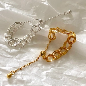 Adjustable silver and gold chain rings on textured background for a minimalist style
