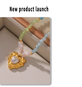 Macro view of gold lava heart pendant with faux pearl on a multi-color beaded necklace