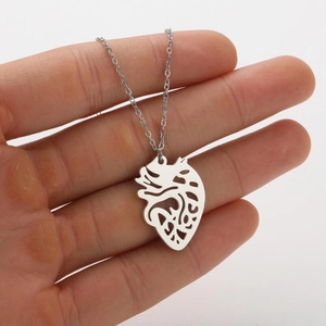 Detailed close-up of a silver anatomical heart pendant on a delicate stainless steel chain
