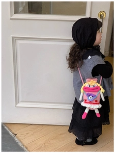 Dettaglio di una borsa a tracolla a bambola rosa fatta a mano su una modella bambina