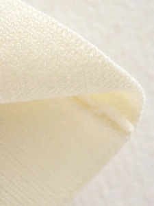 Nahaufnahme des weißen Strickstoffs zeigt die detaillierte Textur und Rippenstruktur