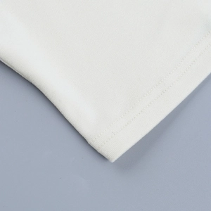 Gros plan de l'ourlet à double surpiqûre et du tricot blanc texturé du haut ajusté