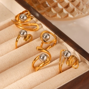 Macro detail of mixed gold and silver tiered sphere rings on a jewelry display tray