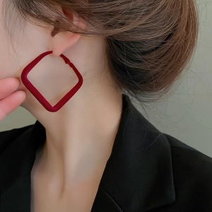 Close-up of model wearing large red square flocked earrings with gold plating