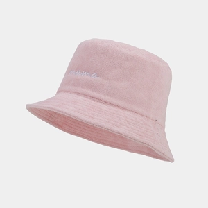 Dettaglio del ricamo bianco 'mama' su un cappello a secchiello in spugna rosa da donna