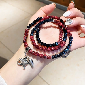 Detail view of rhodochrosite and crystal bracelet with silver elephant and heart charms