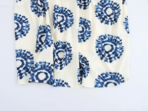 Detail of bohemian halter maxi dress featuring navy blue circular tie-dye prints on cream fabric
