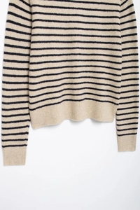 Close-up of the fine knit texture and ribbed hem on a striped long-sleeved sweater
