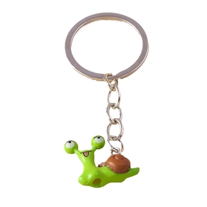 Minimalist green cartoon snail keychain with brown shell on silver ring over white background