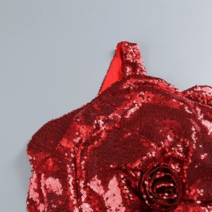 Détail d'une robe rouge à paillettes avec fleur rose 3D artisanale et texture brillante