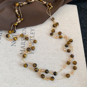 Flat lay of retro layered necklace with tiger eye beads and champagne crystals