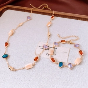 Flat lay of vintage gold jewelry set with colorful square stones and rectangular beads