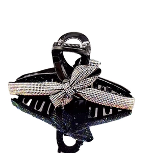 Elegant black claw clip with colorful rhinestone bow ornament against white background