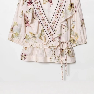 Floral linen wrap top with V-neck ruffle trim and waist tie in beige and pink tones