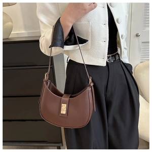 Detailed close-up of dark brown leather crescent bag with elegant gold metal buckle