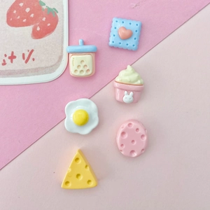 Flat lay of macaron resin charms including milk tea cup and cheese for DIY crafts