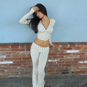 Detail of white two-piece set with black polka dots featuring front zipper and flared pants