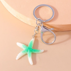 Detail of starfish keychain with green and white gradient resin finish and silver metal ring