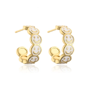 Close-up of gold-plated 18K C-shaped earrings with white enamel smiley faces