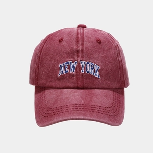 Close-up of vintage washed cotton baseball cap with New York embroidery in burgundy red
