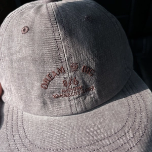 Close-up of vintage washed canvas baseball cap with Dream Big 076 letter embroidery