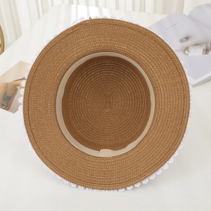 Close-up of the interior structure and white lace trim on the brown straw sun hat