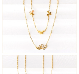 Detail einer zweilagigen Goldkette mit Schmetterlingsanhängern und weißer Muschelfüllung