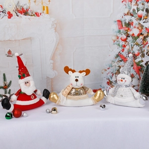 Three sitting Christmas figurines including Santa, reindeer, and snowman with golden sequins