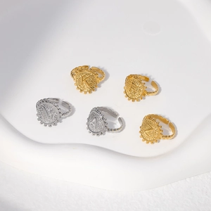 Detail of vintage alphabet coin rings with hammered metal texture in gold and silver