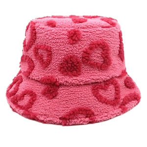 Nahaufnahme des weichen rosa Plüsch-Anglerhutes mit roten Herzmustern für den Winter