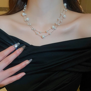 Close-up of double-layered gold plated necklace with irregular pearls on a model